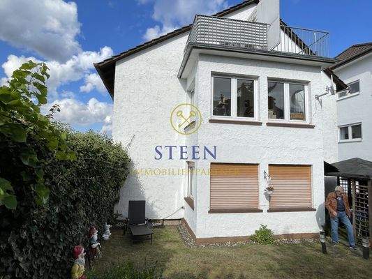 Hausseite mit Terrasse und Garten