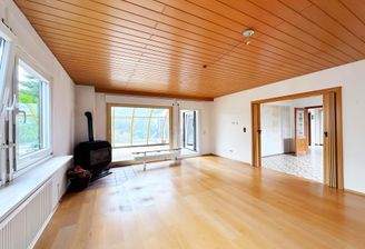 Wohnzimmer mit verglastem Wintergarten.