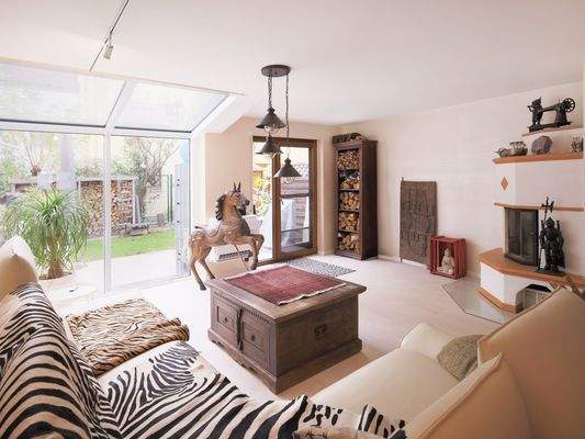 Heller, offener Wohnbereich mit Kamin und Gartenblick