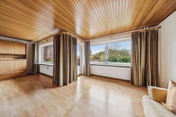 Ihr helles Wohnzimmer mit großen Fenstern und Blick ins Grüne