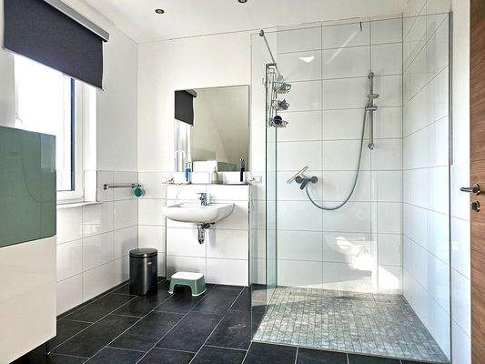 Tageslichtbadezimmer mit bodentiefer Dusche sowie Badewanne