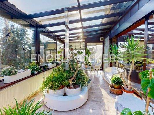 Der großzügige Wintergarten grenzt direkt an den Wohnbereich