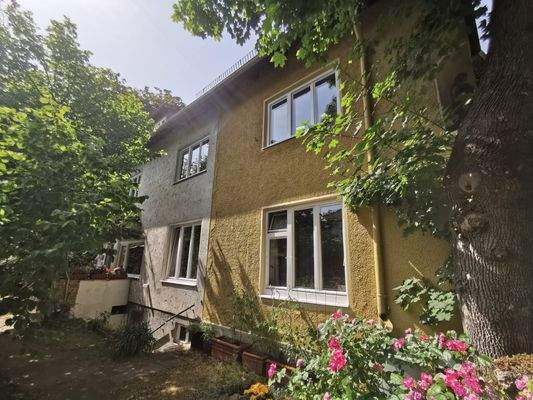 Seitenansicht mit üppigem Blumenschmuck – liebevoll gepflegtes Zuhause.