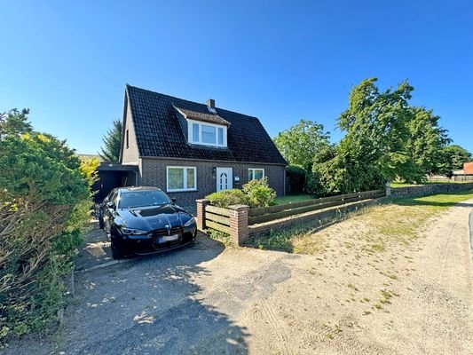 Haus von der Straße aus mit Zufahrt zur Garage und Carport