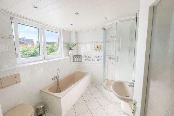 helles Badezimmer mit Badewanne und Dusche