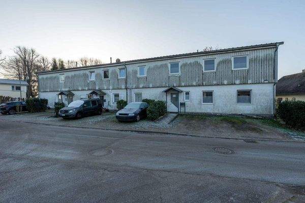 Frontansicht des Mehrfamilienhauses mit sieben PKW