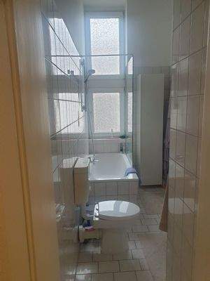 Badezimmer mit großem Fenster und Badewanne