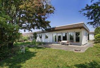 Hausansicht mit überdachter Terrasse und Garten mit viel Privatsphäre