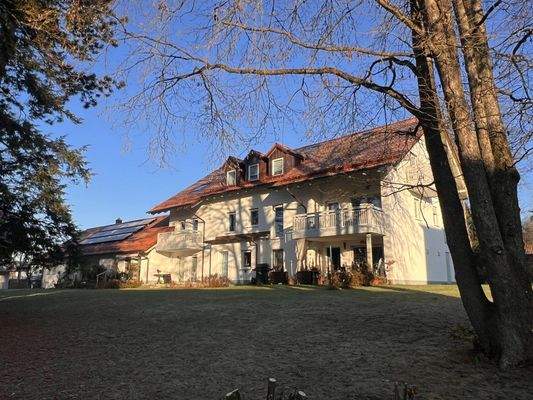 Modernes Mehrfamilienhaus mit Solaranlage und großzügigen Balkonen in idyllischer Waldrandlage