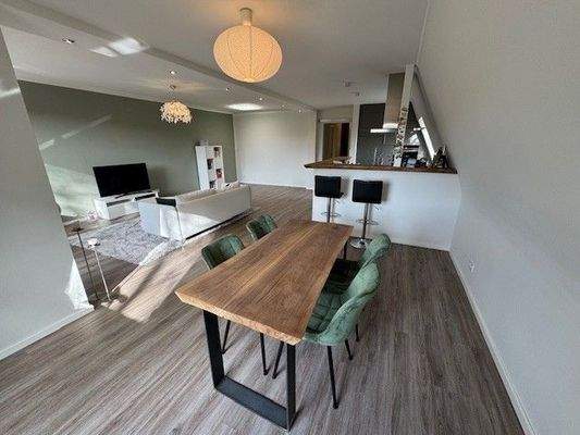 Wohnzimmer mit offener Küche und Essbereich