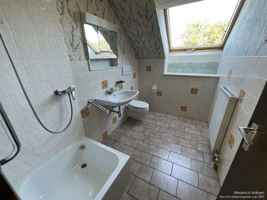 Badezimmer mit Dusche, Waschbecken und Toilette im Dachgeschoss