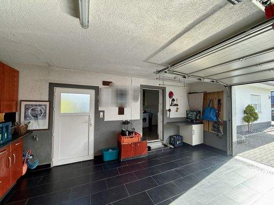 geflieste Garage mit Zugang in den HWR-Raum und in den Garten