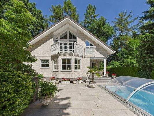 Blick auf das Haus sowie auf den Pool und Terrassenbereich