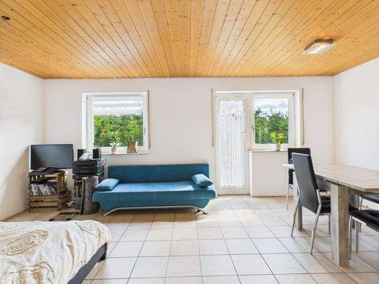 Wohn-Schlafraum in der Einliegerwohnung mit Zugang zur Terrasse/Garten