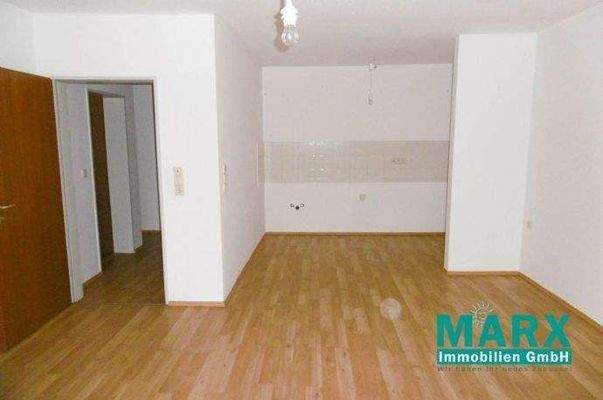 Wohnzimmer mit Blick zum Flur und offener Küche