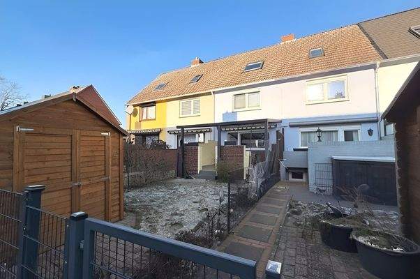 Hausansicht mit Gartenhaus und Terrasse