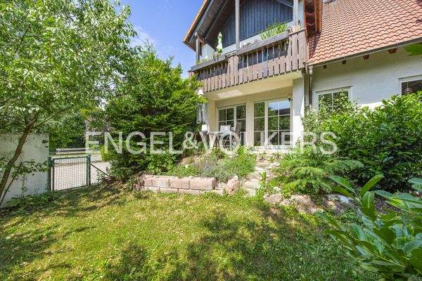 Blick in den grünen und eingezäunten Garten, auf die  teilüberdachte Terrasse sowie auf das Gartentürchen zur Garage