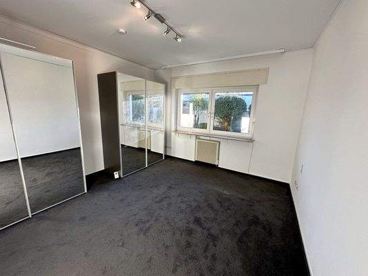 Lichtdurchflutetes Zimmer mit Spiegelschrank und Gartenblick