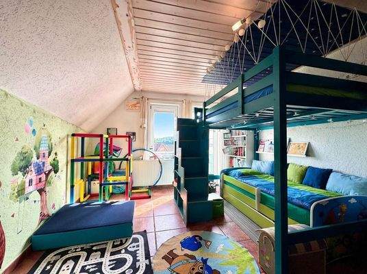 Kinderzimmer mit Hochbett und Spielfläche