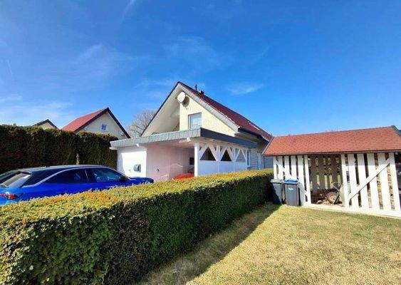 Einfahrt mit Carport 
Rechts der Hecke städtisches Pachtgrundstück, was zum Haus angegliedert ist.