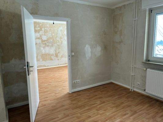 Schlafzimmer/Wohnzimmer mit PVC-Bodenbelag in Holzoptik mit tapezierfähigen Wänden.