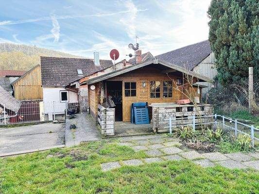 Westansicht mit Terrasse und großem Gartenhaus