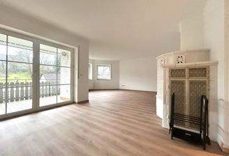 Großzügiger Wohnbereich mit Kamin und Balkonzugang