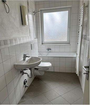 Tageslichtbad mit Wanne, weißer Wand- und hellgrauer Bodenverflisung.JPG