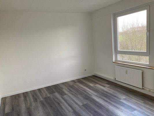 Schlafzimmer mit dunkelm Boden und großem Fenster.jpg