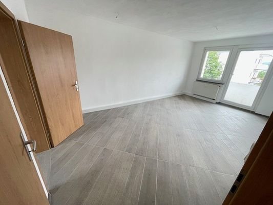 Wohnzimmer mit Balkon und Schlafzimmer