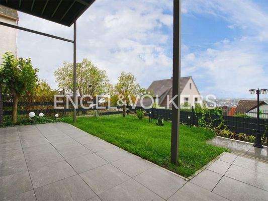 Großzügige überdachte Terrasse mit angrenzendem Garten
