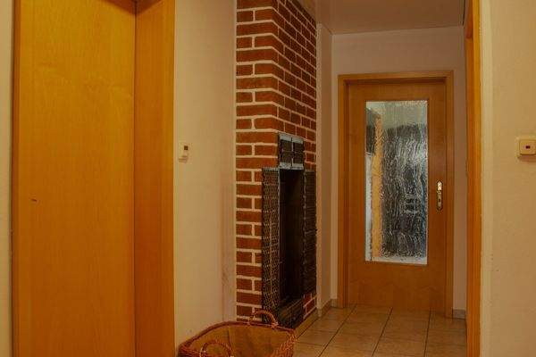 Flur im Erdgeschoss mit Befeuerung des Kachelofens