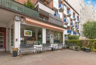 Sichtbare Ladenfront mit Sitzgelegenheiten im Außenbereich