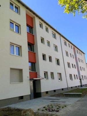 Vorderansicht Gebäude mit  Hauseingang, Fenstern und Begrünung