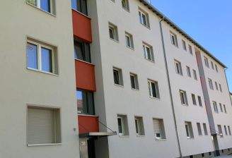 Vorderansicht Gebäude mit  Hauseingang, Fenstern und Begrünung