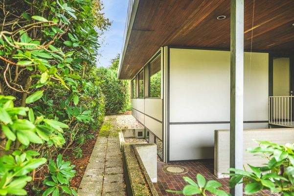 Überdachte Sitzecke und Weg um das Haus 