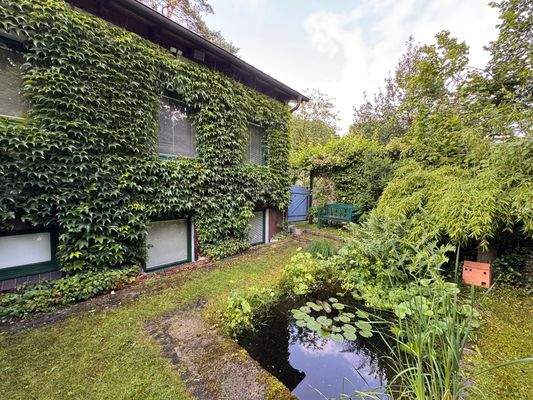 Begrünte Fassade sowie Teich