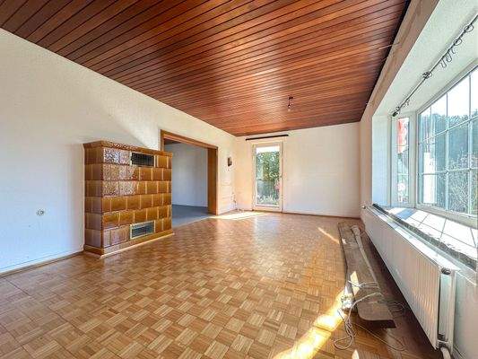 Wohnzimmer mit Erkerfenster und traditionellem Kachelofen