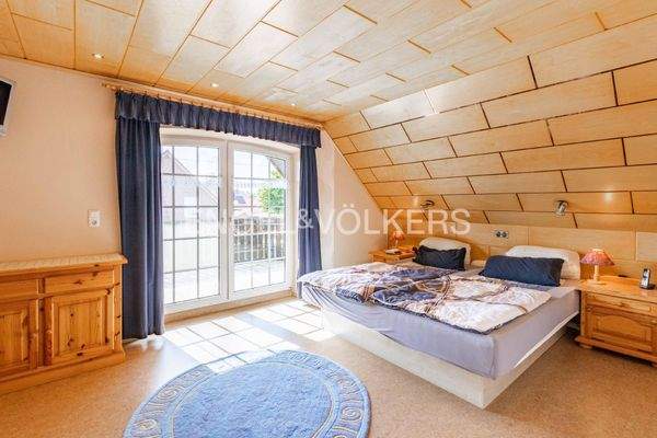 Schlafzimmer im Obergeschoss mit angrenzendem Ankleidezimmer und Zugang zur Loggia