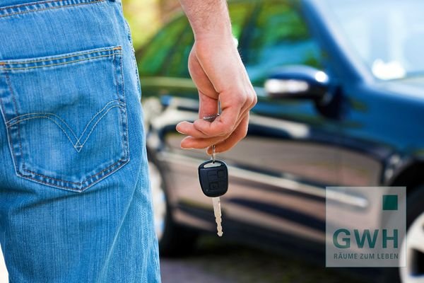 Person mit Schüssel vor Auto