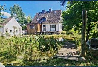 Idyllischer Blick vom eigenen Gartenbereich mit Schwimmteichauf das tolle Einfamilienhaus