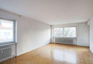 Geräumiges Wohnzimmer mit Balkonzugang und Parkettboden