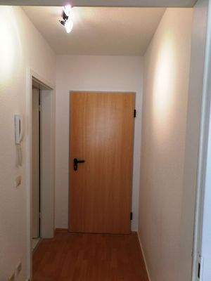 Heller Flur mit Holztür