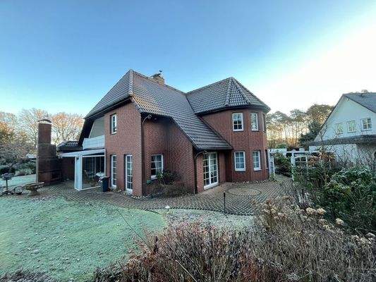 Rückansicht mit überdachter Terrasse, Loggia und Außenkamin
