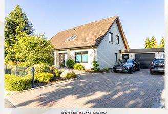 Die Vorderansicht mit großer Auffahrt, Garage und ansprechendem Vorgarten mit vielfältiger Bepflanzung