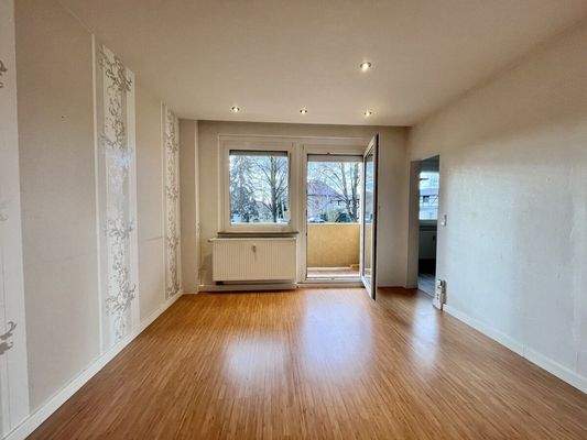 2025-3365-Wohnzimmer mit Zugang zur Küche und Balkon