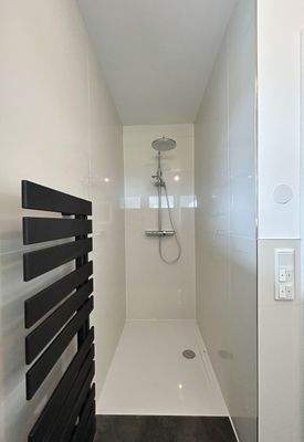 Duschbereich im Badezimmer mit Designheizkörper