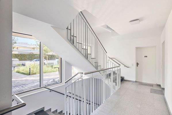 Helles Stiegenhaus mit Personenaufzug in alle Geschosse