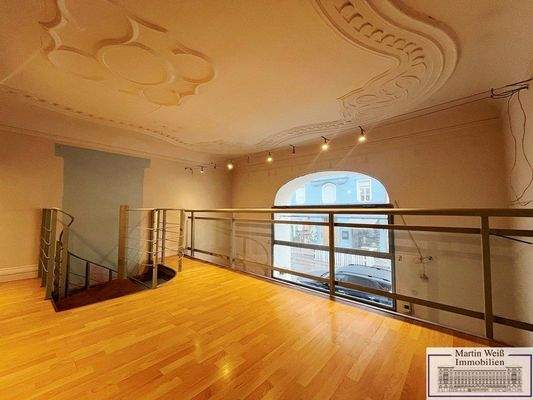 Galerieebene mit Deckenstuck und Blick zum Schaufenster