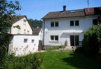 Haus Südseite: links Einzelgarage, Tür zu den Kfz-Stellplätzen, Zuweg vom Garten auf die Terrasse am Haus.